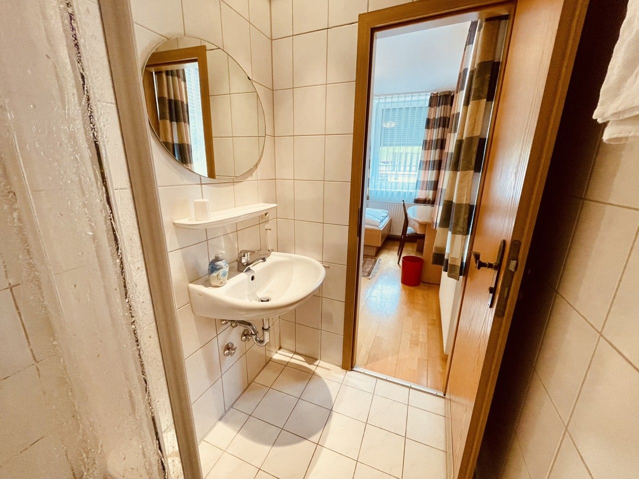 Ein Badezimmer mit Waschbecken, Spiegel und Duschbereich.