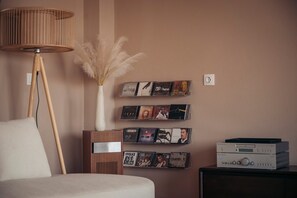 A room with a floor lamp, a wall-mounted CD rack, a vase with dried plants, and a stereo system. - Stefanos Rock, Villa (Corfu)