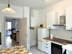 Una cocina moderna con armarios blancos, un microondas, una estufa y un lavabo.