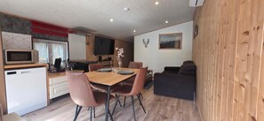 Un espace de vie compact comprenant une cuisine, un coin repas et un espace détente.