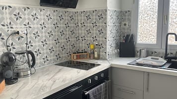 Cozinha moderna com máquina de lavar louça, fogão e janela com vista.
