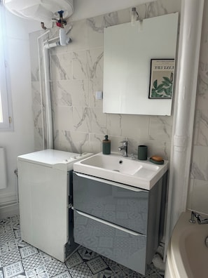 Ein Badezimmer mit einem weißen Waschbecken, einem Spiegel und einer Toilette.