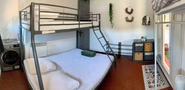 A bunk bed with a ladder, a small table with a plant, and a wall-mounted mirror. - New Listing (Le Barcarès)