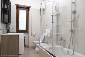 Une salle de bain moderne avec une douche à parois de verre, des toilettes et un lavabo.
