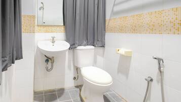 A bathroom with a white sink, toilet, and shower.