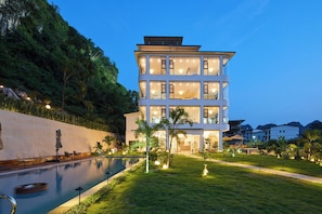 A multi-story hotel with a swimming pool and a well-maintained garden. - YUN SHEN SHAN YUAN Homestay Yulong (Guilin)