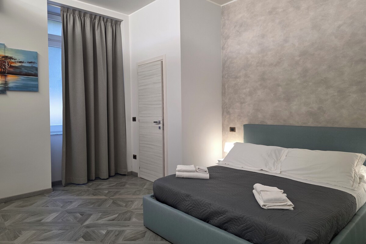 Un dormitorio con cama, una puerta y un cuadro en la pared.