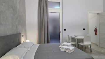 Una habitación de hotel con cama, escritorio, silla y extintor.