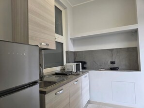 Una cocina moderna con refrigerador, microondas y estufa integrados.