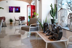 Un intérieur moderne comprenant un coin salon, un téléviseur fixé au mur et diverses plantes.