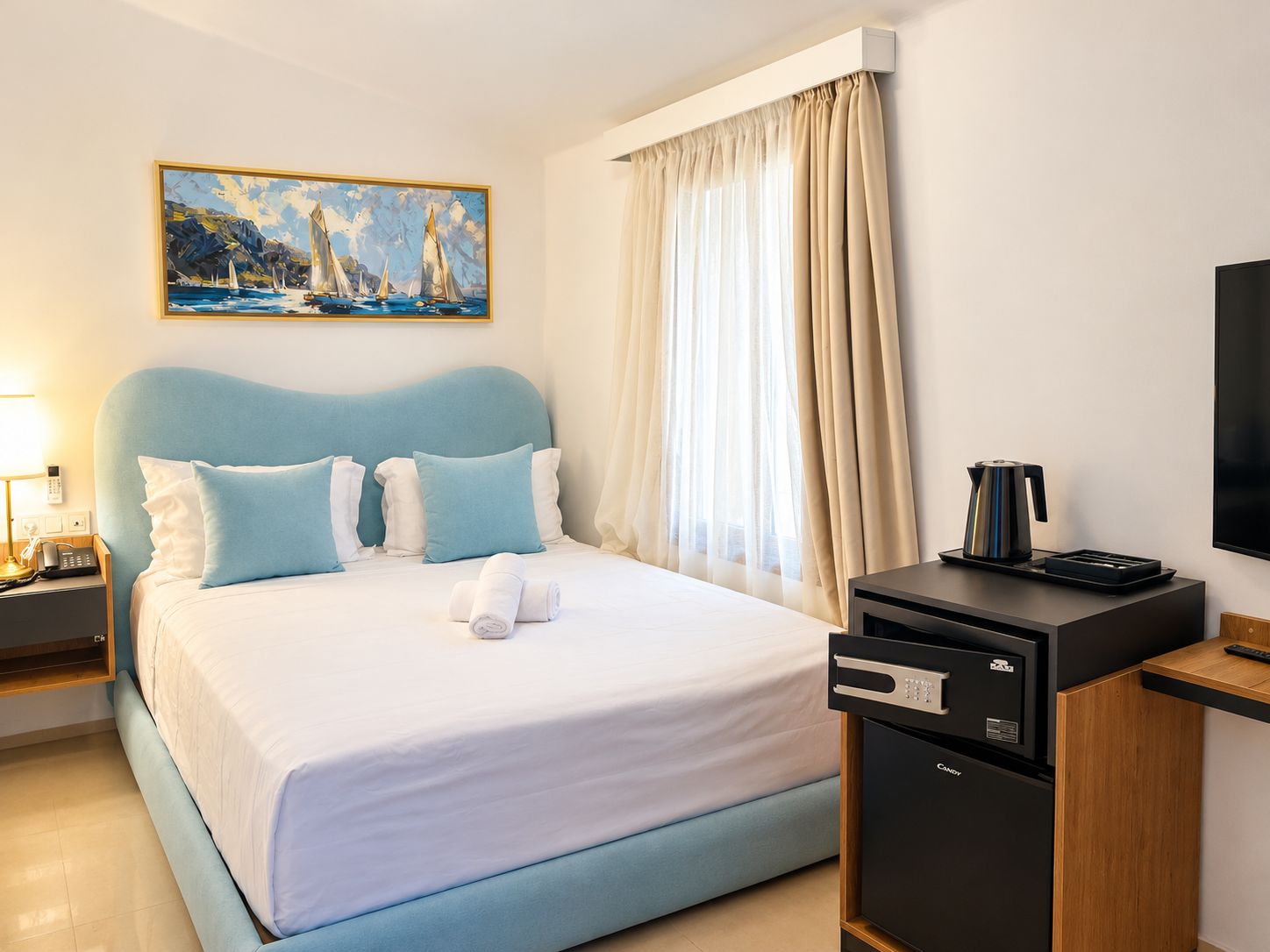 A hotel room with a bed, a painting, a coffee maker, and a TV.