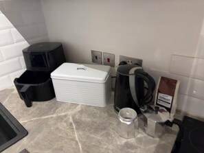 A kitchen with a coffee maker, a kettle, a coffee pod dispenser, and a trash bin. - The Loft, Bright, Spacious apartment centre St Ives, Full kitchen, two bed rooms (St Ives)