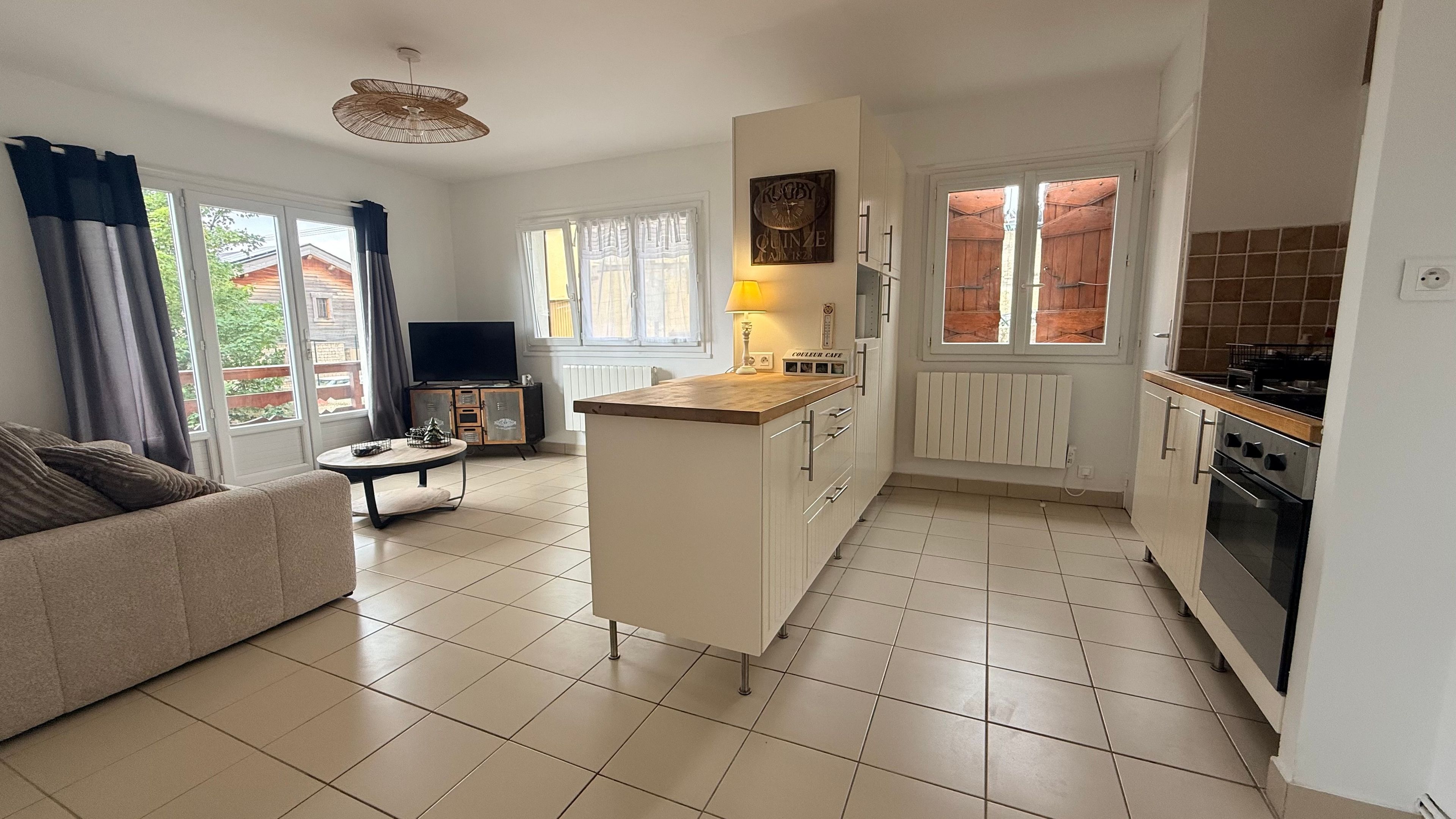 Un espacio habitable compacto con kitchenette, comedor y sofá.
