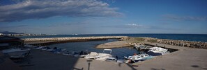 A marina with boats docked, a stone breakwater, and a clear sky. - Room with Private Bathroom and Air Conditioning – Cagnes-sur-Mer (Cagnes-sur-Mer)