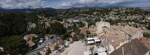 A town with a central square, buildings with traditional architecture, and a mountainous backdrop. - Room with Private Bathroom and Air Conditioning – Cagnes-sur-Mer (Cagnes-sur-Mer)