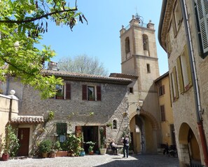 A courtyard with stone buildings, a bell tower, and potted plants. - Room with Private Bathroom and Air Conditioning – Cagnes-sur-Mer (Cagnes-sur-Mer)
