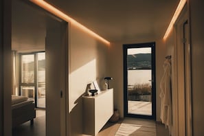 A modern bathroom with a large window, a bedside table, and a towel rack.