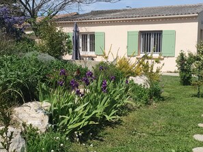 Ein Haus mit Garten, Terrasse und einer Straßenlaterne.