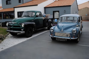 Two vintage cars parked in a driveway.