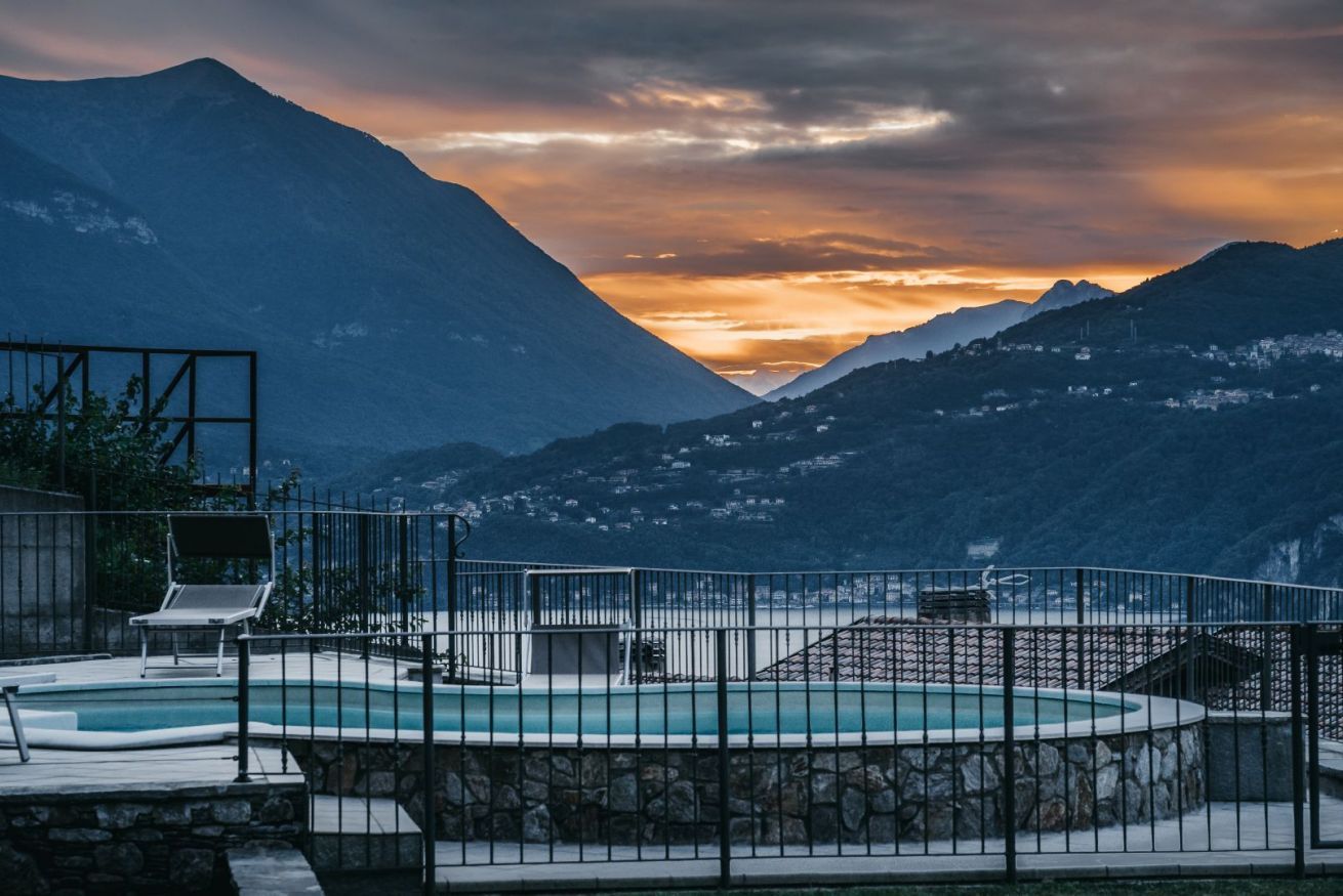 Area piscina con vista sulle montagne al tramonto.