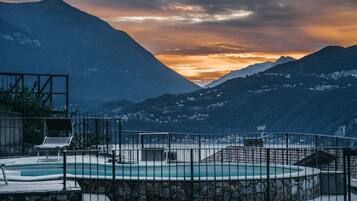 Area piscina con vista sulle montagne al tramonto.