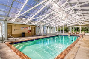 An indoor swimming pool with a glass ceiling, clear signage, and a lifeguard station. - Mountains View Condo, Pool Access, WIFI (Pigeon Forge)