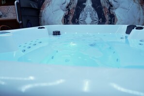 A hot tub with jets, a control panel, and a marble wall in the background. - New Listing (Breuschwickersheim)