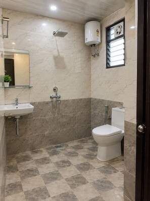 A bathroom with a shower, toilet, sink, and a mirror. - The Forest View Resort (Sawai Madhopur)