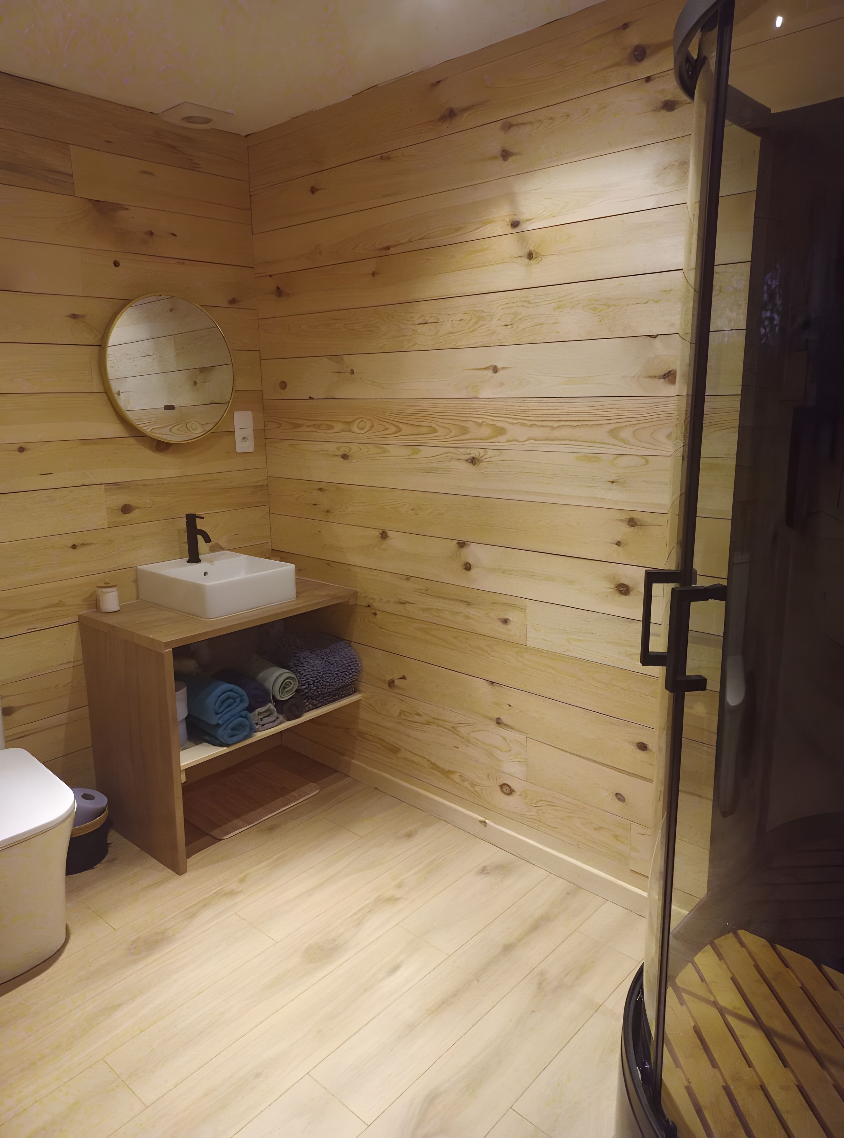 Un baño con paneles de madera, un lavamanos, un espejo y estanterías.