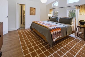 A bedroom with a bed, a window, a door, and a rug. - Mcfoy Ranch 20 Acres, Sleeps 8 (Wimberley)