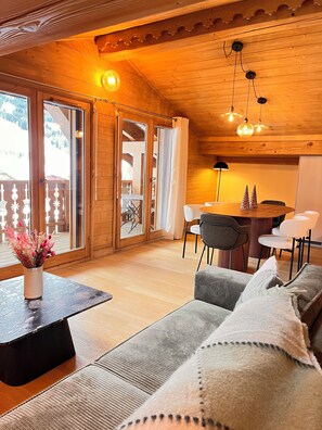 A wooden interior with a sofa, a dining table, and chairs. - New Listing (Praz-sur-Arly)