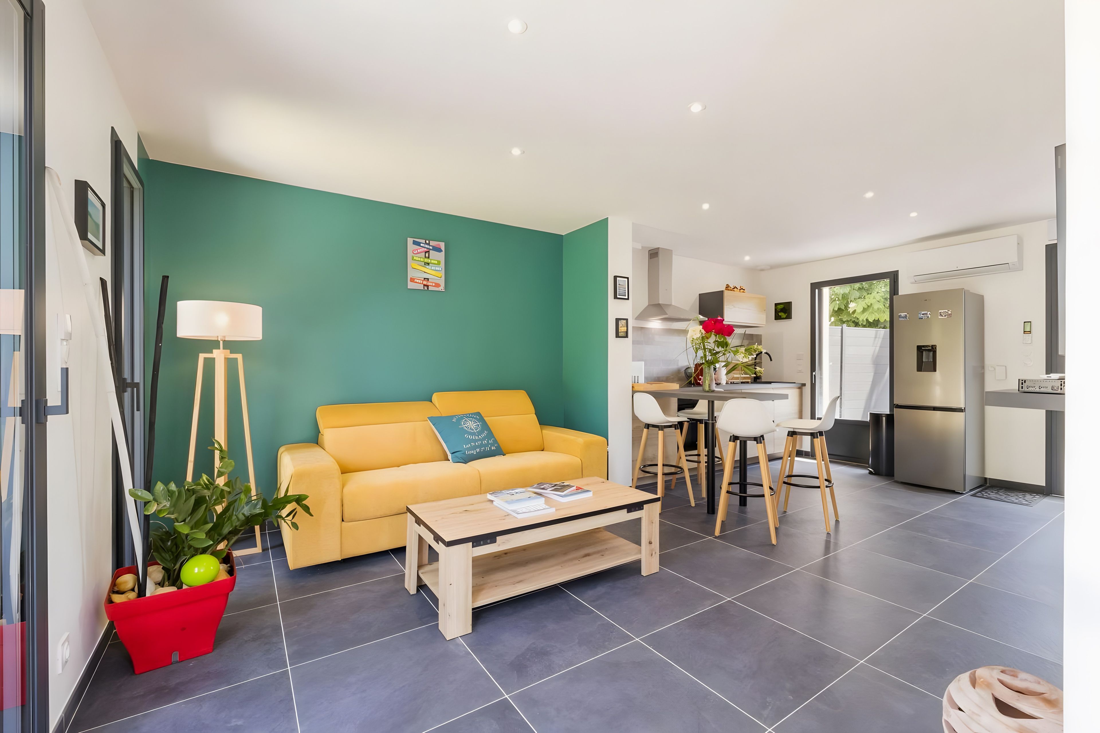 Un salon moderne avec un canapé, une table basse et un coin repas avec des chaises.
