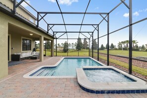 A covered outdoor swimming pool area with a patio and seating. - Valley Retreat. Spacious 9-bedroom house in peaceful ChampionsGate with AC (ChampionsGate)