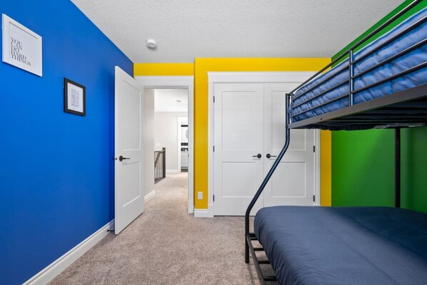 A room with a bunk bed, a door leading to a hallway, and a framed inspirational quote on the wall. - 3BR Main & Upper Floor in Airdrie | Sleeps 9 | Canal View (Airdrie)