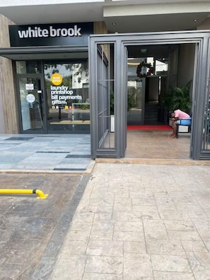 A storefront with a sign reading 'white brook' and a glass door entrance. - Zen Cantonments Studio · WiFi, Pool, Gym & Balcony (Accra)