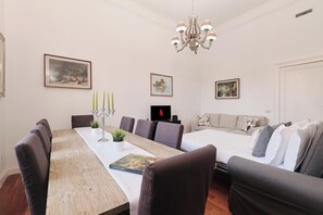 A modern living room with a dining area, a chandelier, and artwork on the walls. - New Listing (Roma)