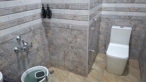 Een badkamer met douche, toilet en een douchetoilet.