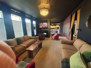 Una sala de estar con un sofá, sillones, una mesa de centro y un televisor.