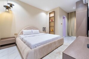 Una camera da letto moderna con un letto grande, comodini, una parete attrezzata e una televisione.