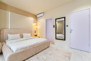 Quarto com cama, guarda-roupa, espelho e ar condicionado.