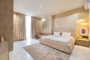 Camera da letto moderna con un letto grande, un comodino, una sedia e una grande finestra con tende.