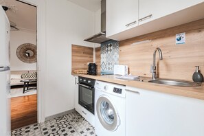A compact kitchen with a washing machine, a coffee maker, and a toaster. - New Listing (Reims)