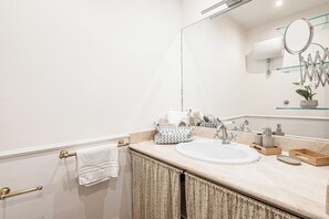 A bathroom with a white sink, a mirror, and a towel rack. - New Listing (Roma)