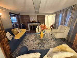 Een woonkamer met een bank, fauteuil en salontafel met decoratieve objecten.