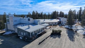 A large, multi-story building with a flat roof, surrounded by trees and snow. - Tiera Resort (Taivalkoski)