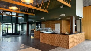 A spacious lobby with a central island counter, large windows, and a high ceiling with exposed beams. - Tiera Resort (Taivalkoski)