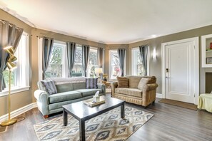 A living room with a sofa, armchair, coffee table, and a lamp.