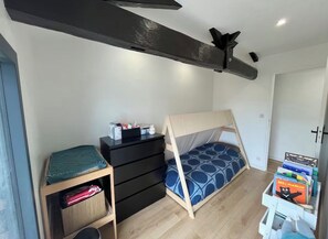 A bedroom with a bunk bed, a dresser, a small shelf, and a white cabinet. - New Listing (Sainte-Hélène)