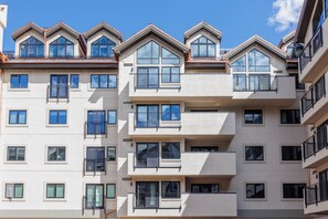 A multi-story residential building with balconies, large windows, and a modern architectural design. - New Remodel Penthouse by InvitedHome | Walk to Ski/Town, Hot Tub, Pool, Gym (Beaver Creek)