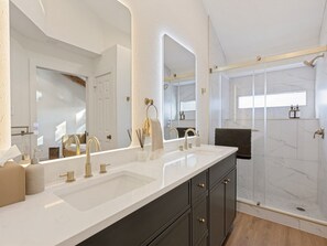 A modern bathroom with a large mirror, dual sinks, and a walk-in shower. - Newly Remodeled Western 3BR House With Cowboy Pool - Quiet and Great Location (Austin)